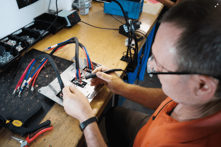 Technician connecting wires and testing electrical equipment