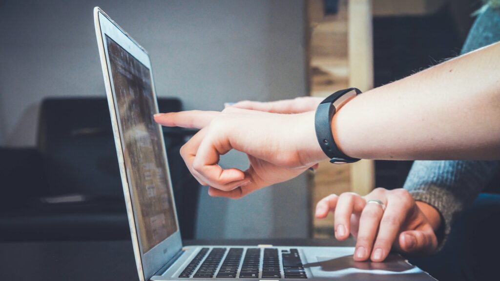 Hands pointing at laptop