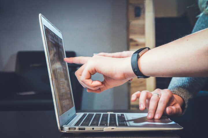 Hands pointing at laptop