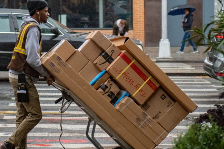 Man pushing boxes on transport cart