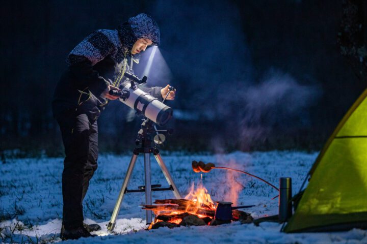 Astronomer Adjusting and Preparing Telescope By His Camp in Winter.