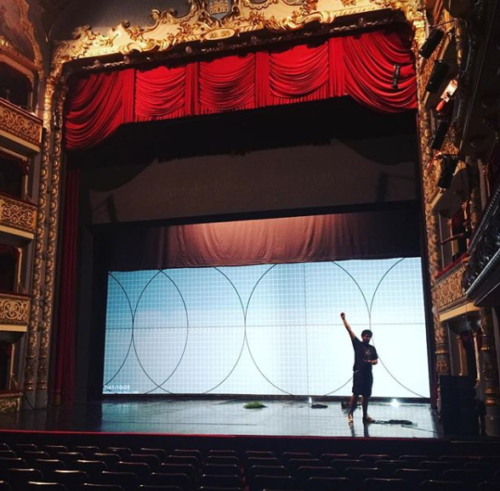 man on stage waving